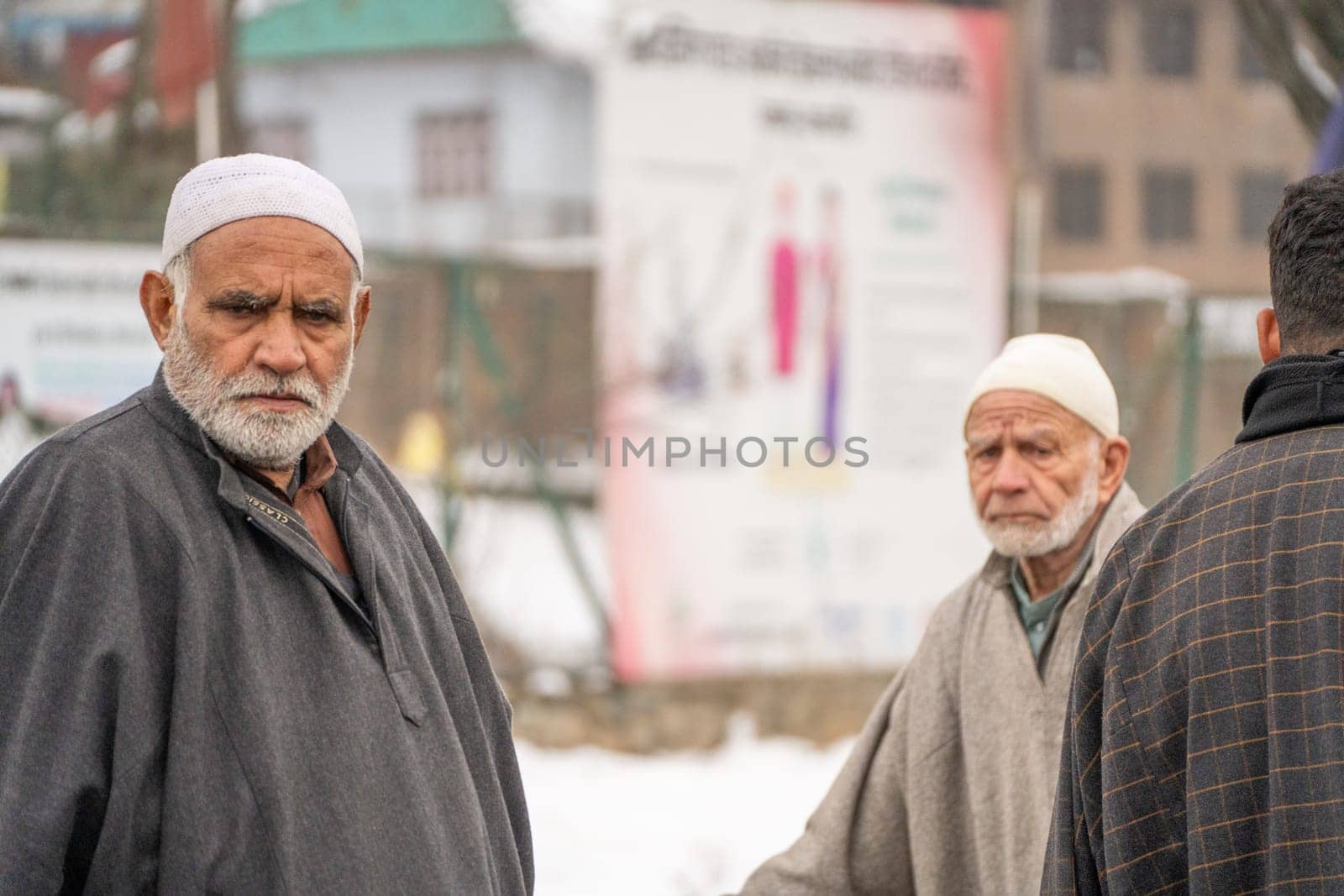 Srinagar, Kashmir - 4th Jan 2025: Group of elderly men walking along a street and looking at the passerby in Kashmir India