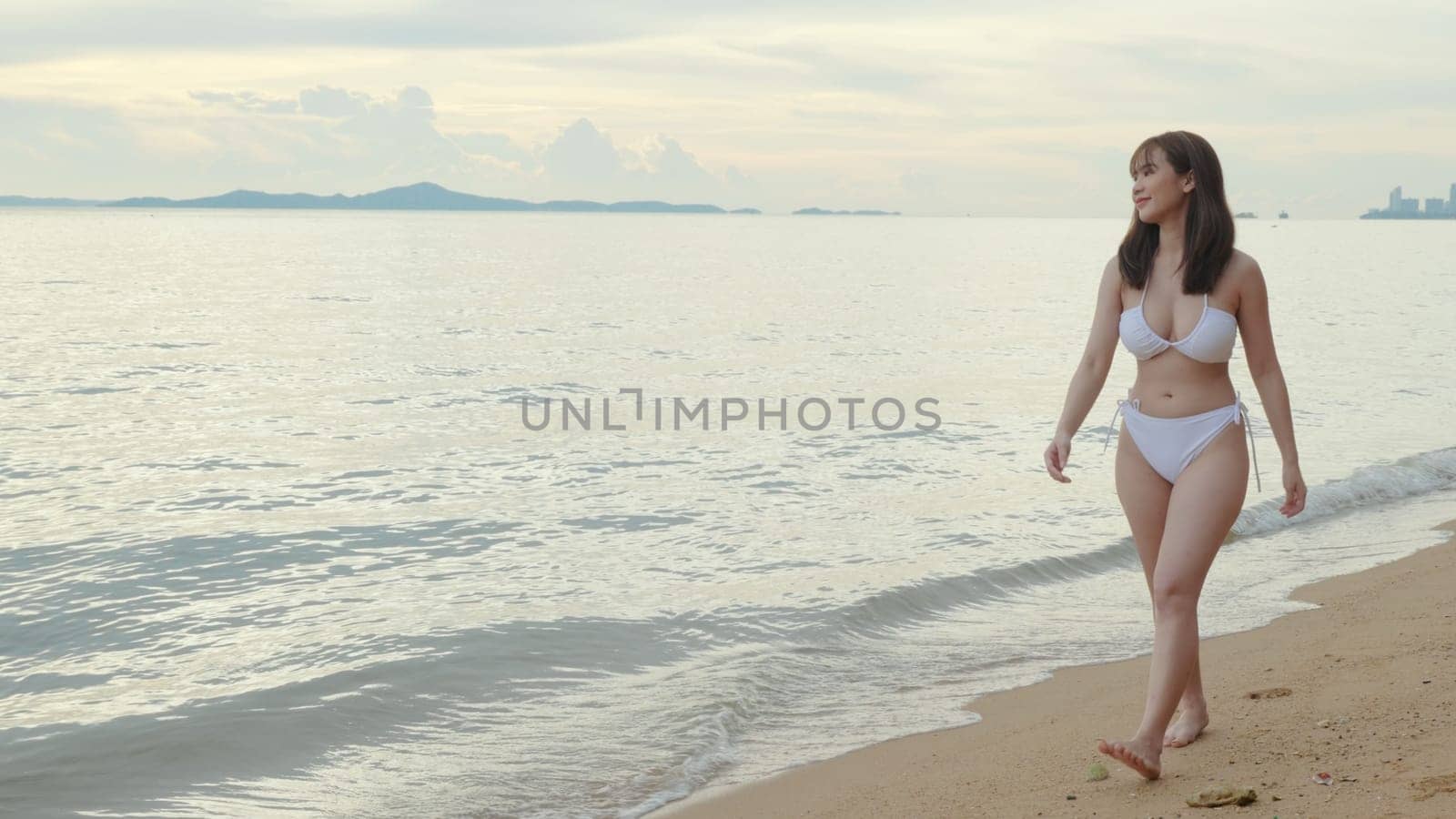 Young beautiful woman wearing bikini swimsuit walking smiling resting relax along on tropical white sand beach, Happy Asian female walk holiday outside, Summer travel vacation concept