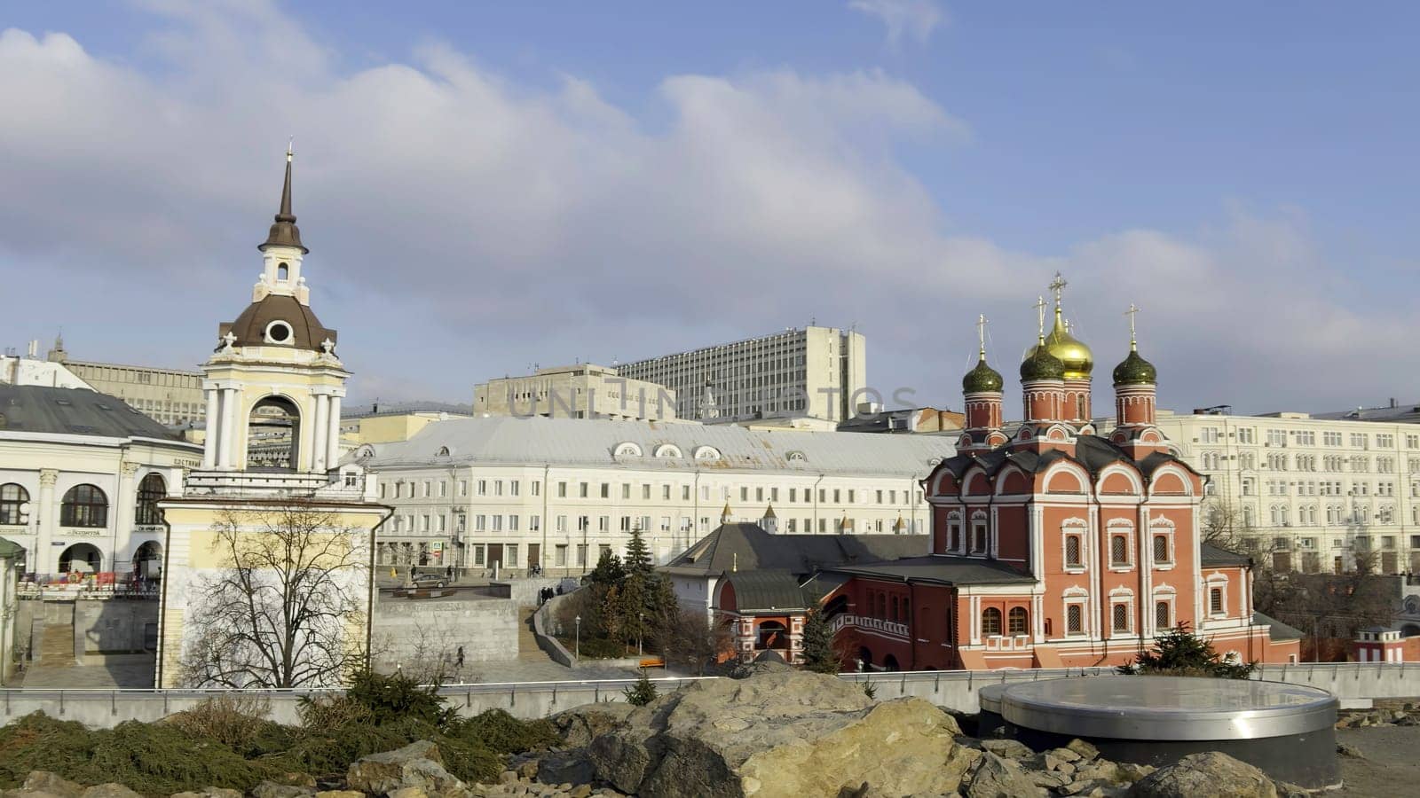 Urban landscape featuring zaryadye park with its scenic overlooks showcasing historic churches and modern buildings under a bright sky