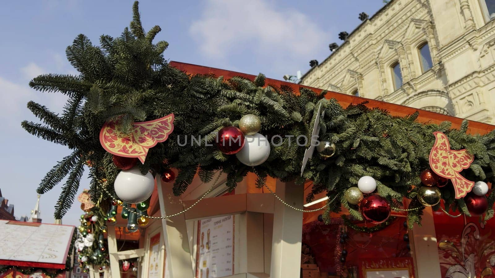 Christmas garland with red and white baubles and wooden birds decorating a market stall in red square, moscow