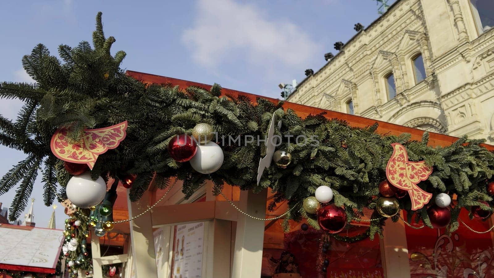 Christmas garland with red and white baubles and wooden birds decorating a market stall in red square, moscow