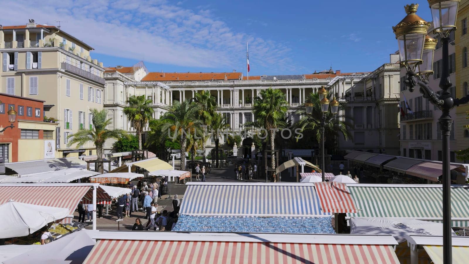 Cours saleya market, located in the heart of vieux nice, offers a vibrant atmosphere with colorful awnings, palm trees, and bustling shoppers