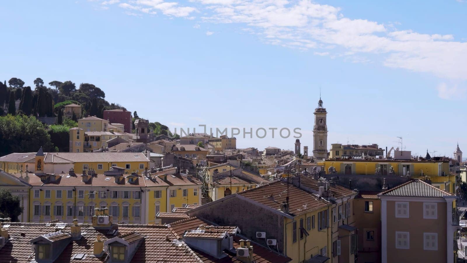 Cityscape of grasse, france, featuring tile roofs and a clear blue sky