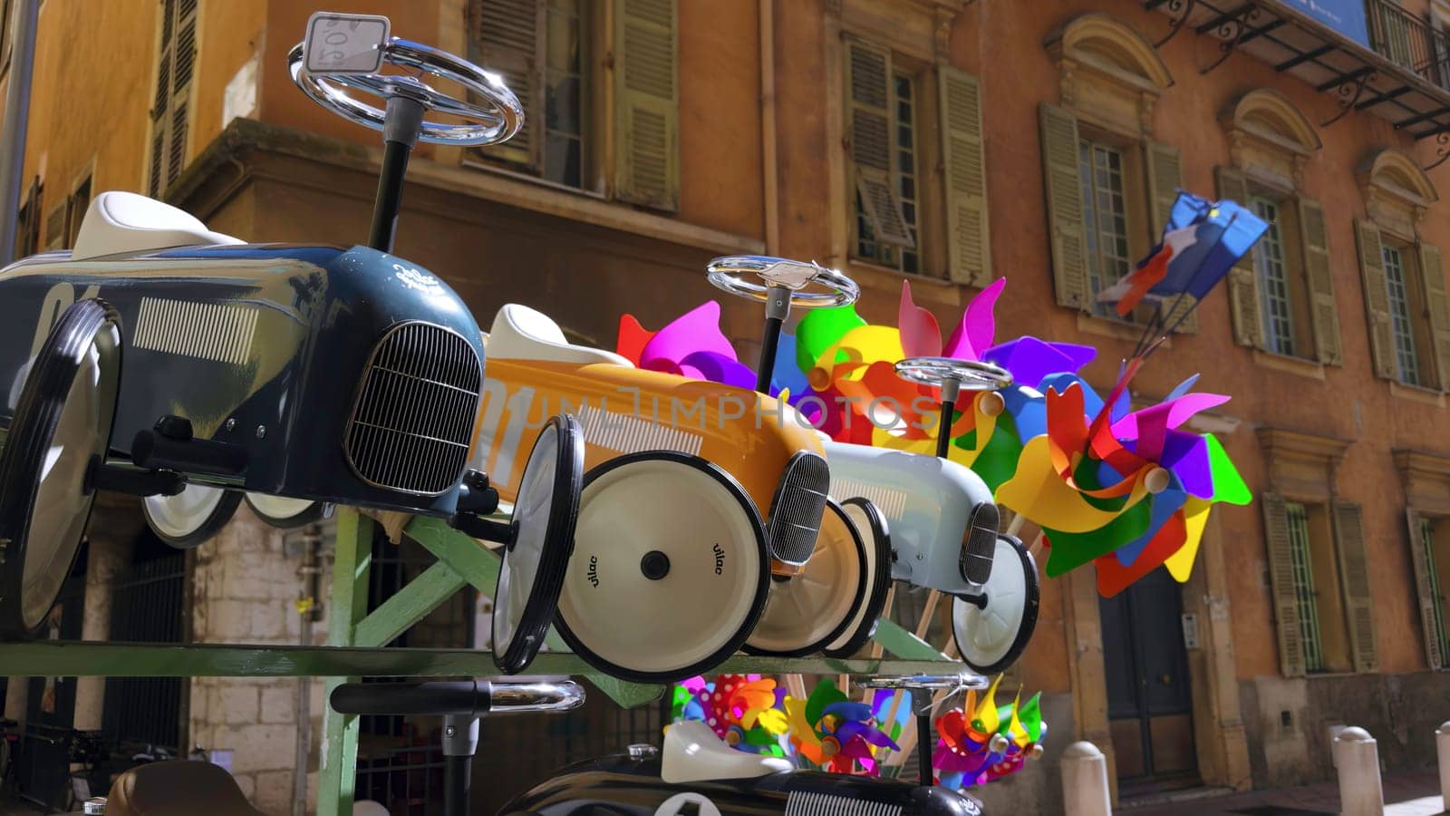 Toy cars and colorful pinwheels decorate a street in a french city