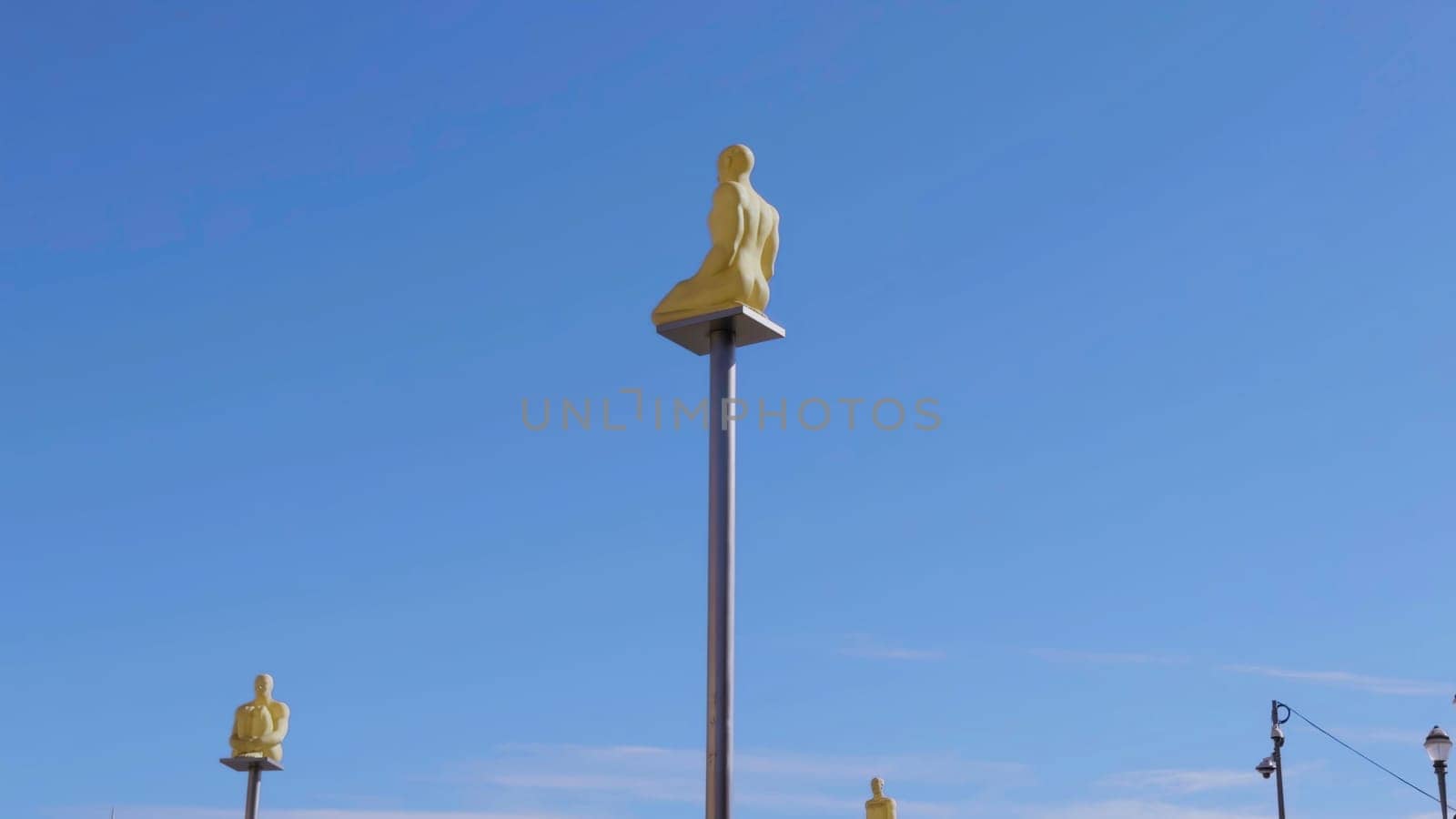Golden statues sitting on poles against a clear blue sky