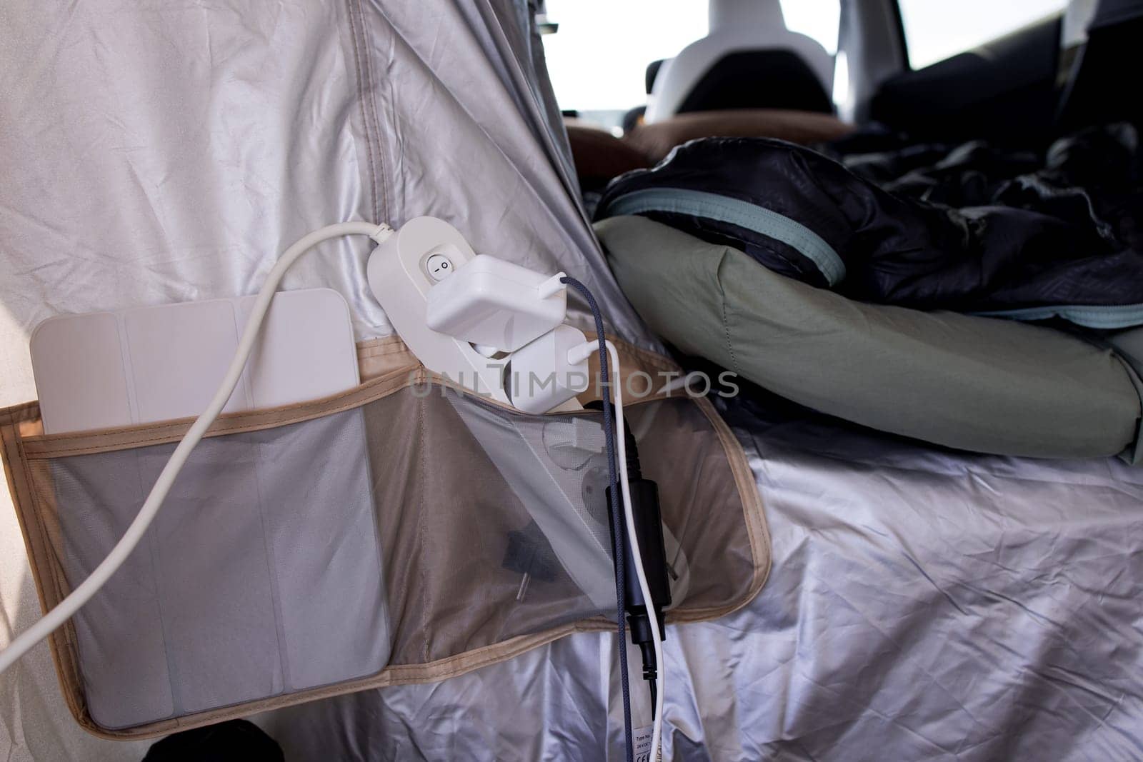 Camping tent interior with charging station and sleeping bag setup.