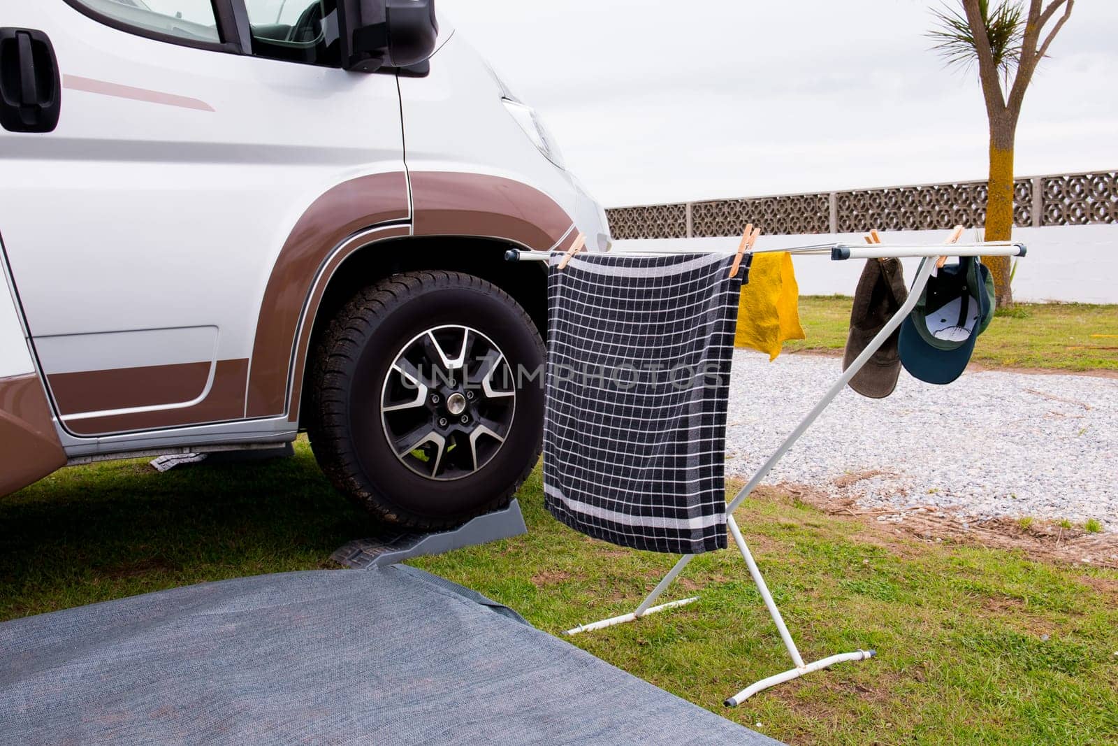 Camper van exterior with drying laundry on rack outdoors in campsite.