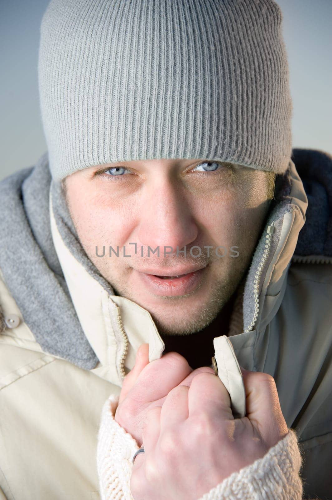 Man in warm gray jacket and hat. Close up.