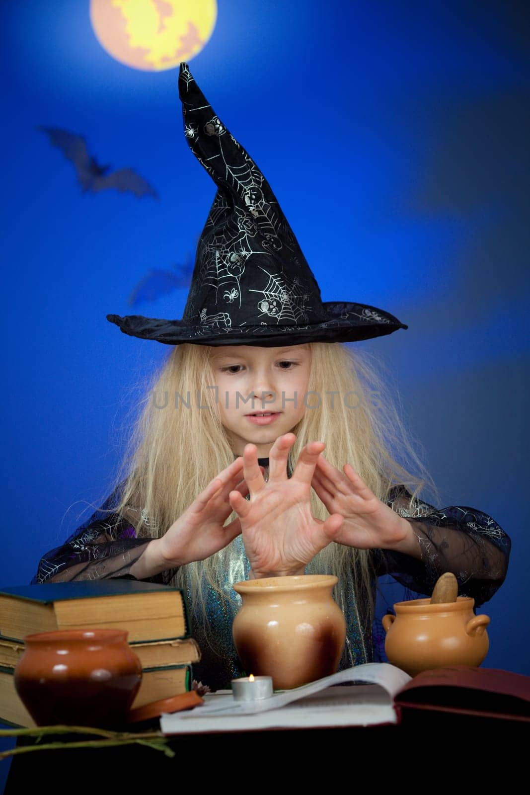 Girl dressed up as witch in night making magic