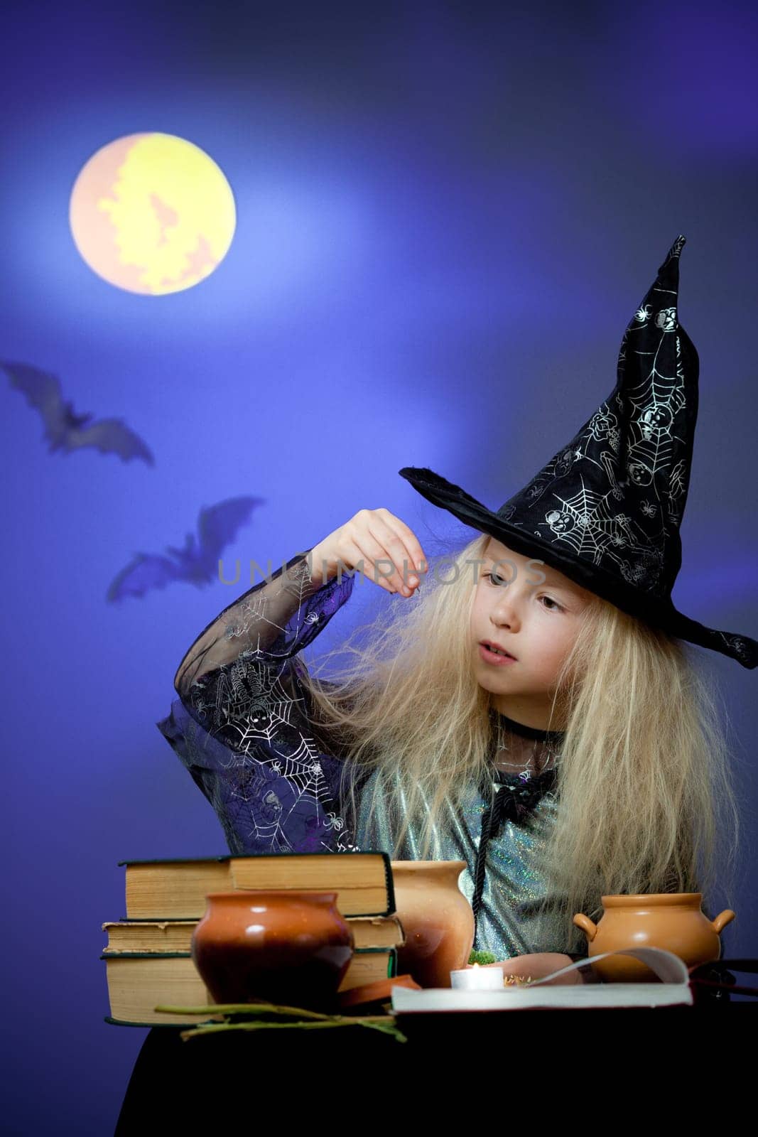 Girl dressed up as witch in night making magic