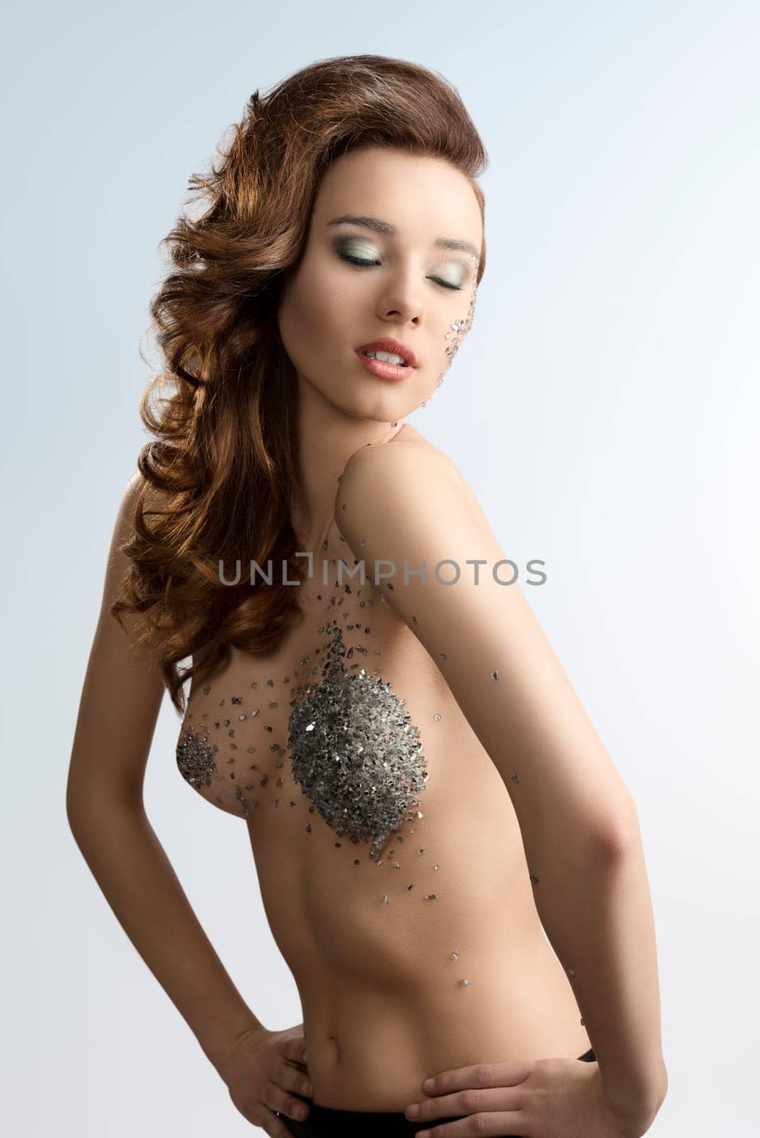 cute young girl with fashion hair-style and creative make-up. Some bright decorations on her face and naked body