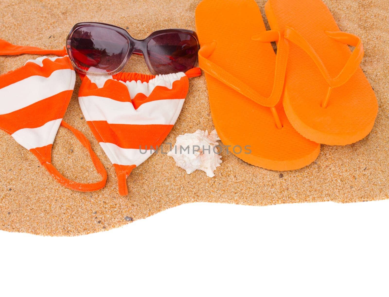 orange sandals and swimming siut on sand  isolated on white background