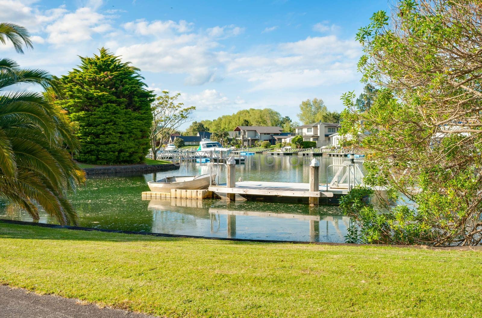 Waterway living luxury homes and piers with boats in idyllic setting in Pauanui New Zealand.