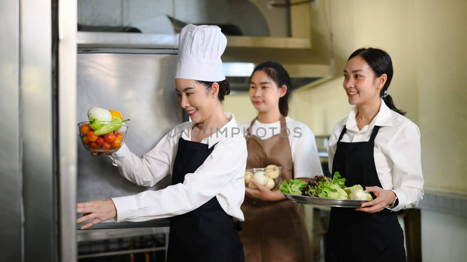 Young chefs preparing ingredients for a cooking class in a professional kitchen.