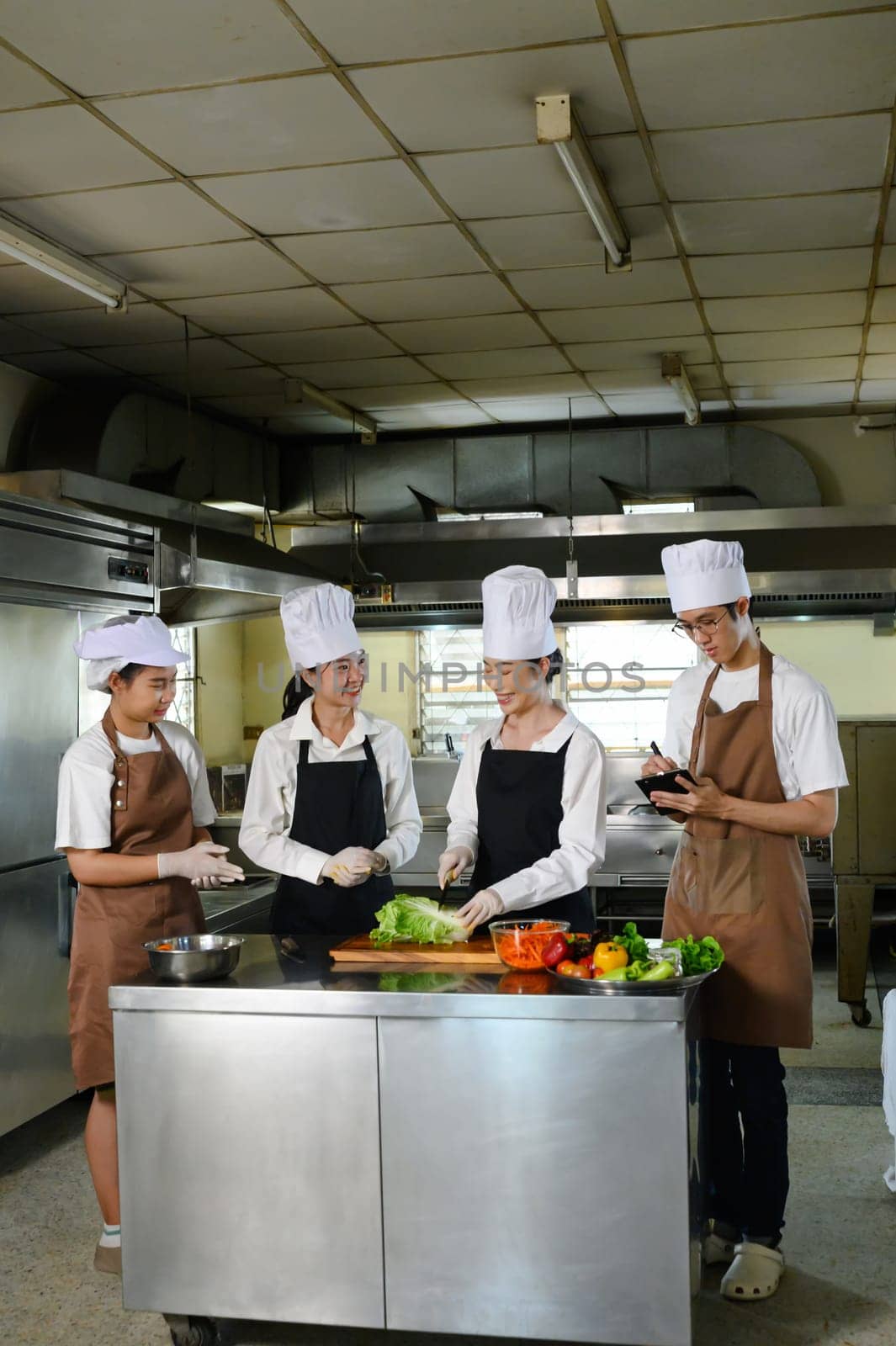 Cooking instructor demonstrating slicing techniques to students during culinary class.