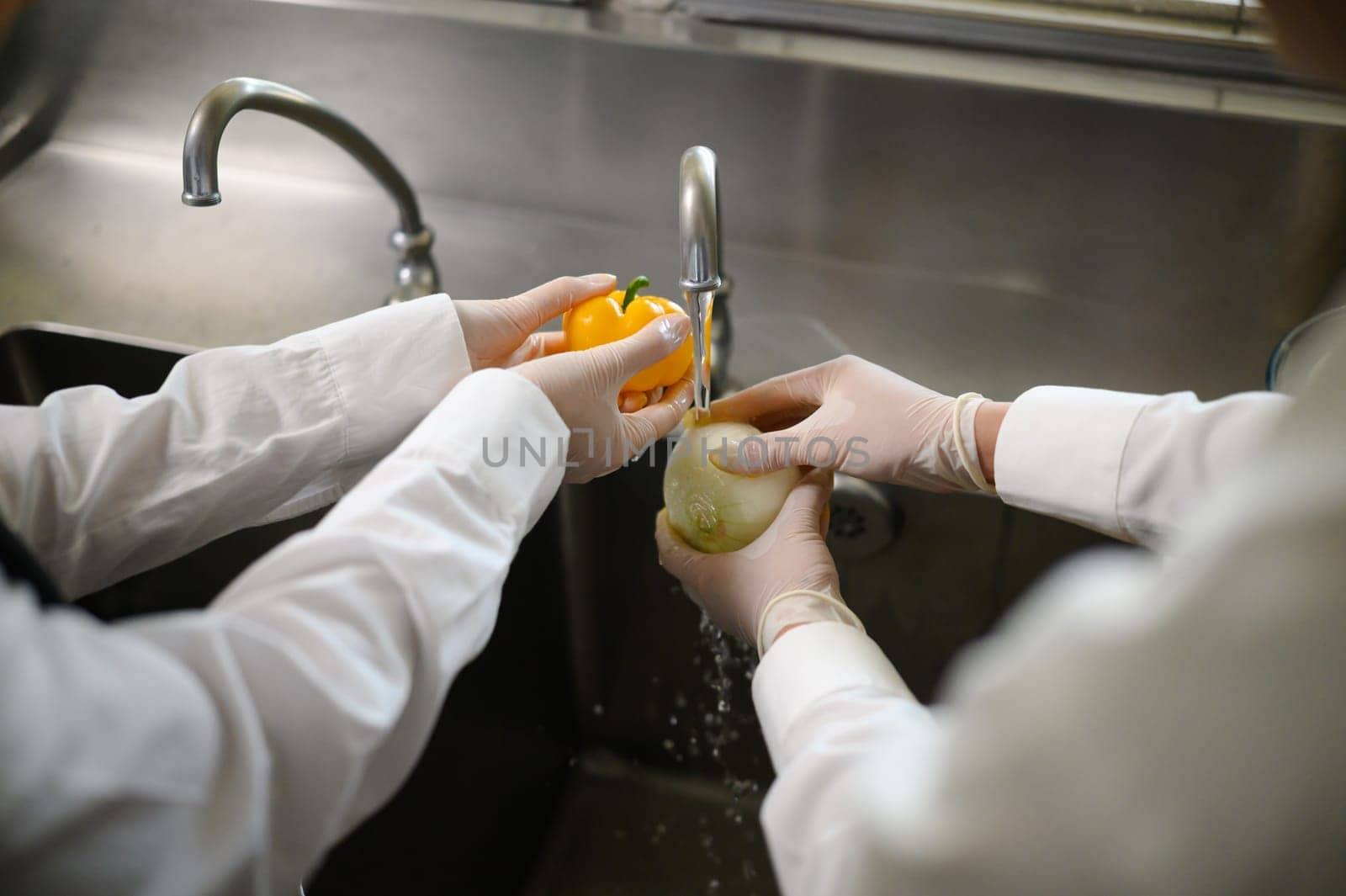 Close up of hands washing fresh vegetables during cooking class.