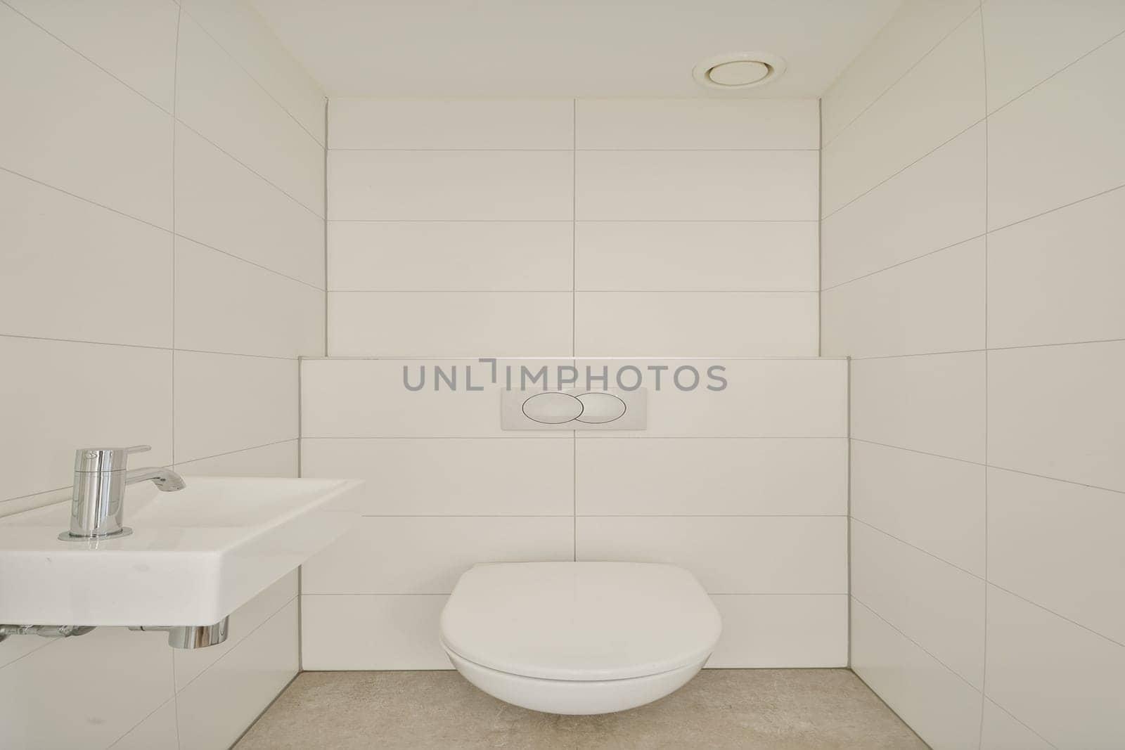 This image showcases a sleek, minimalist bathroom featuring a white toilet and sink against a clean, tiled wall. The design emphasizes simplicity and purity.
