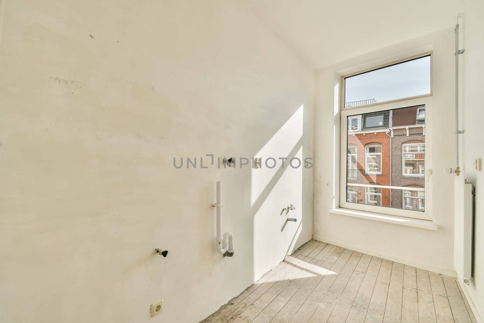 Bright and airy room featuring a large window. The space is designed with a minimalist aesthetic, showcasing the potential for modern interiors.
