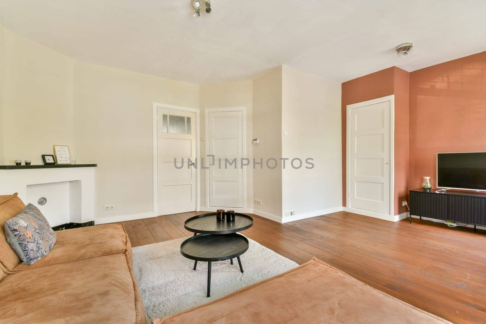 A spacious modern living room featuring a cozy couch, artistic decor, and elegant flooring, designed for comfort and sophistication.