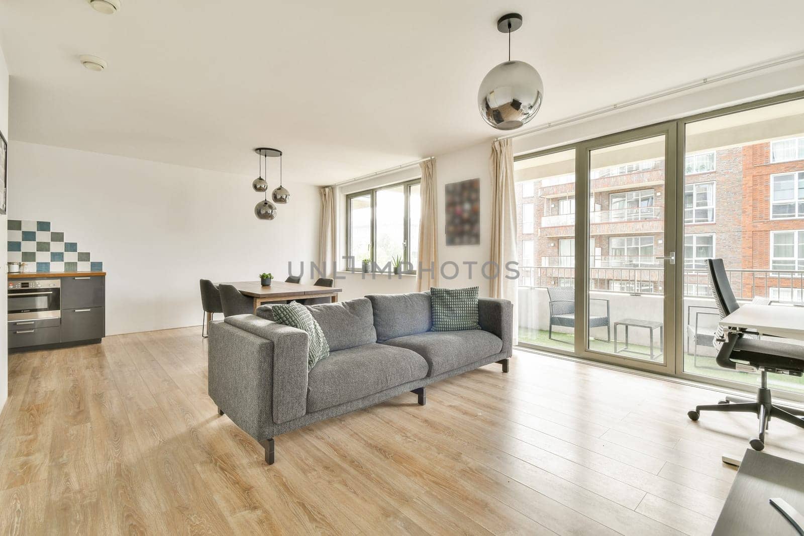 A stylish contemporary living room featuring large windows, comfortable seating, and modern decor elements, creating a bright and inviting atmosphere.