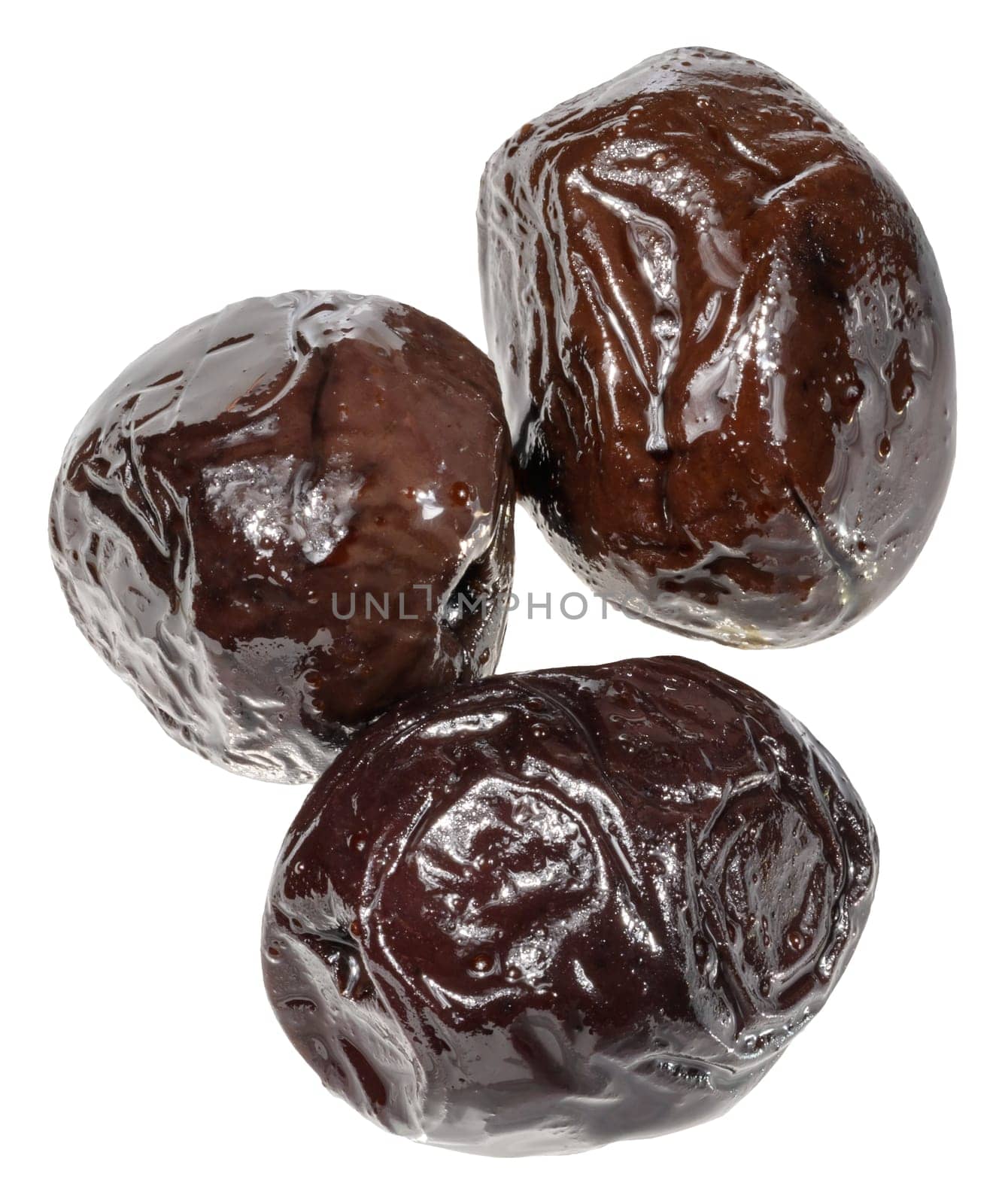 Three smooth, pitted black olives with a shiny, slightly wet surface are grouped together, isolated background