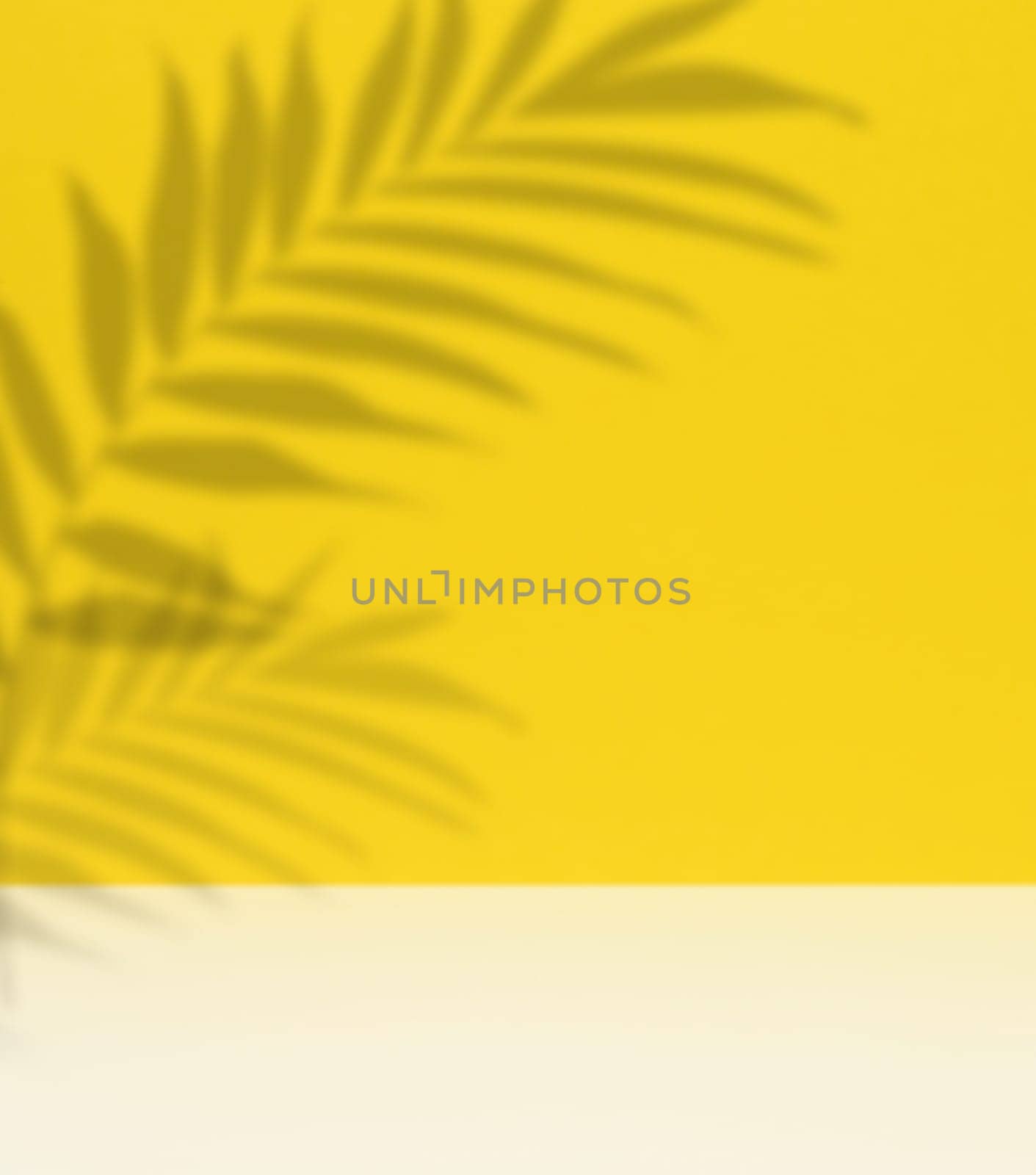 Soft, blurred shadows of palm leaves are cast across a solid light yellow background, creating a subtle and organic texture with copy space.