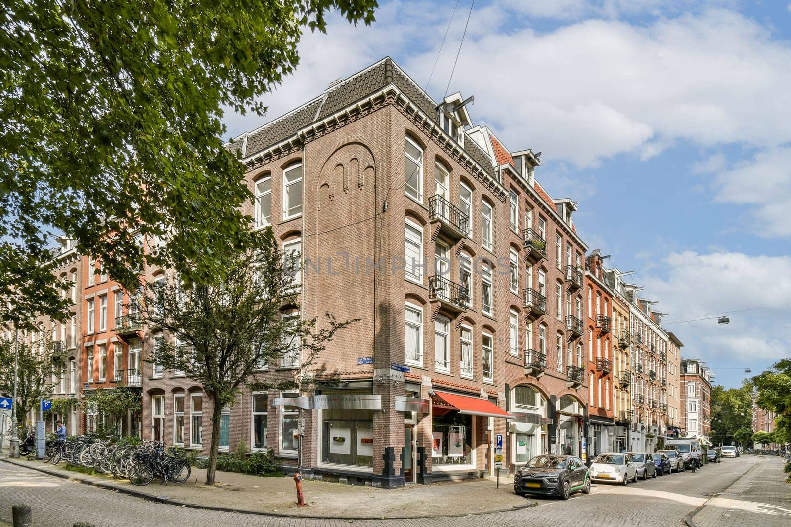 A picturesque street scene featuring a blend of quaint architecture and greenery, showcasing a lively urban atmosphere with bicycles and tree-lined sidewalks.