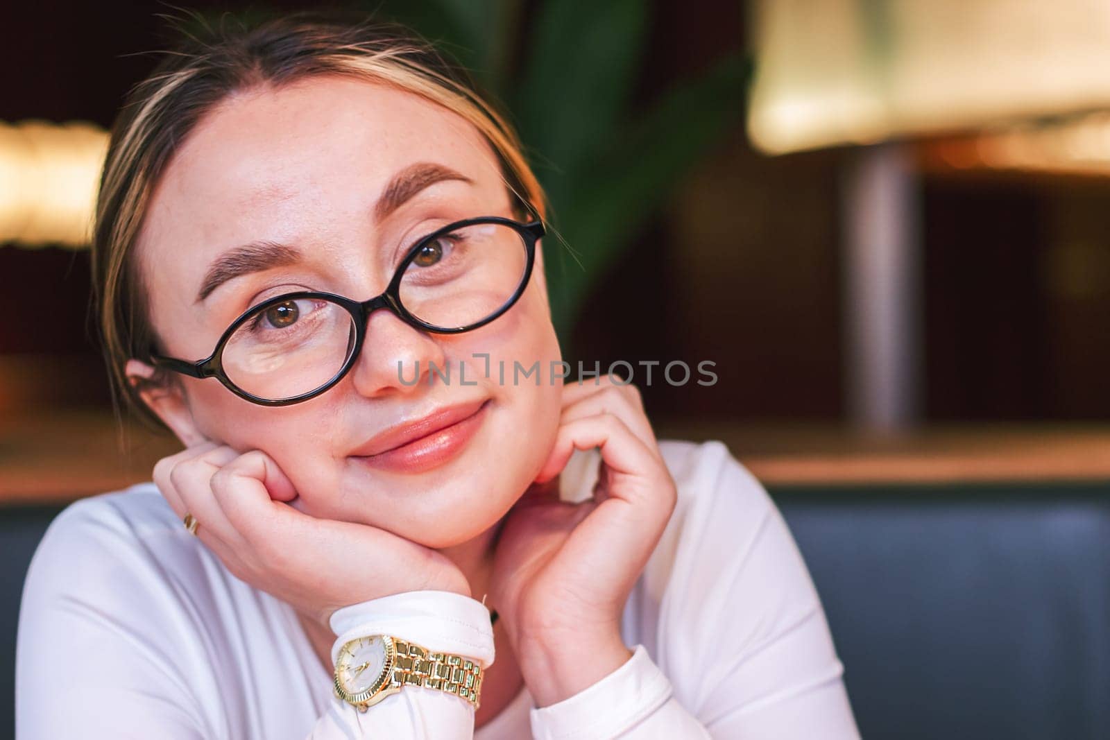 Portrait of a pretty girl in glasses looking at the camera. High quality photo