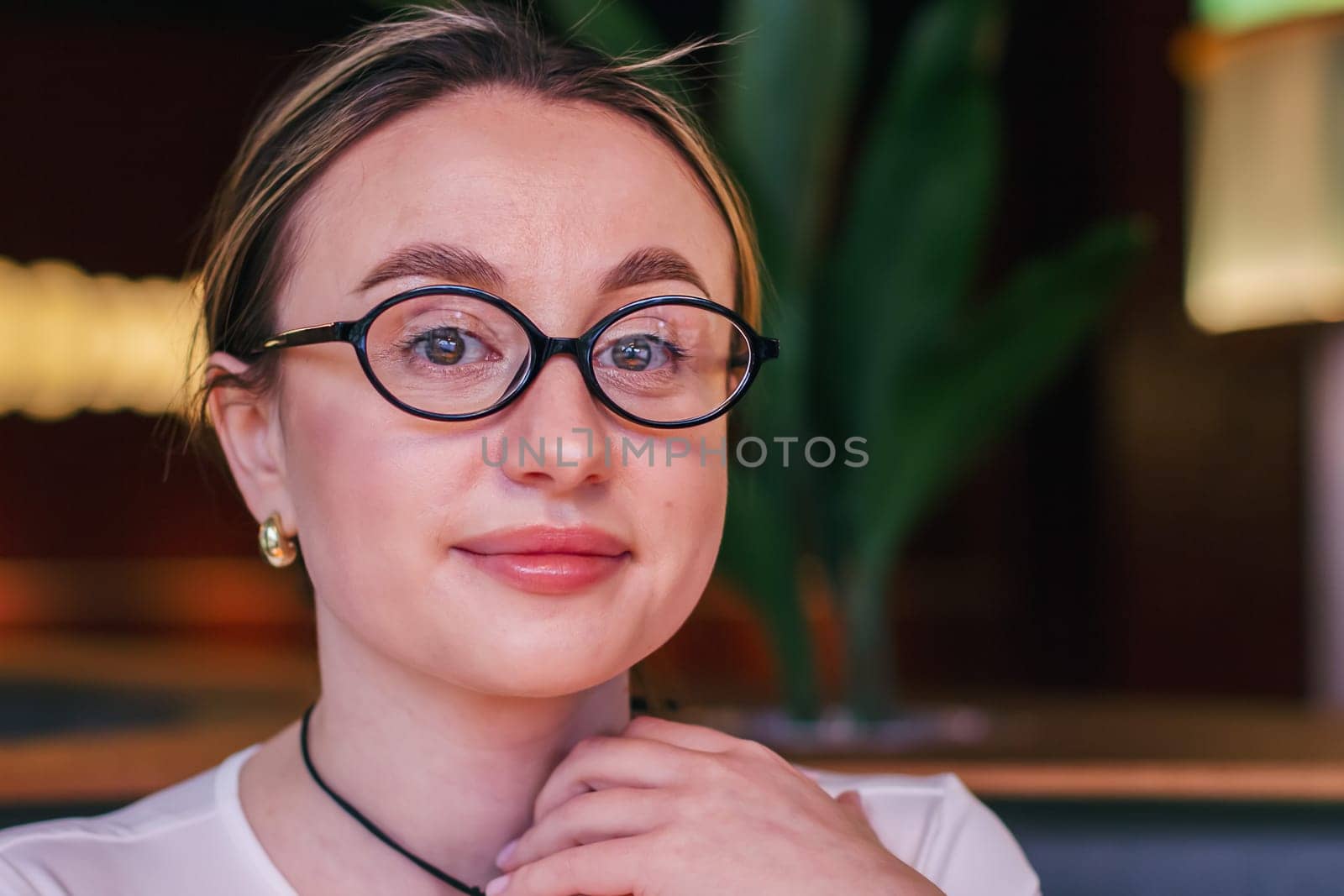 Portrait of a pretty girl in glasses looking at the camera. High quality photo