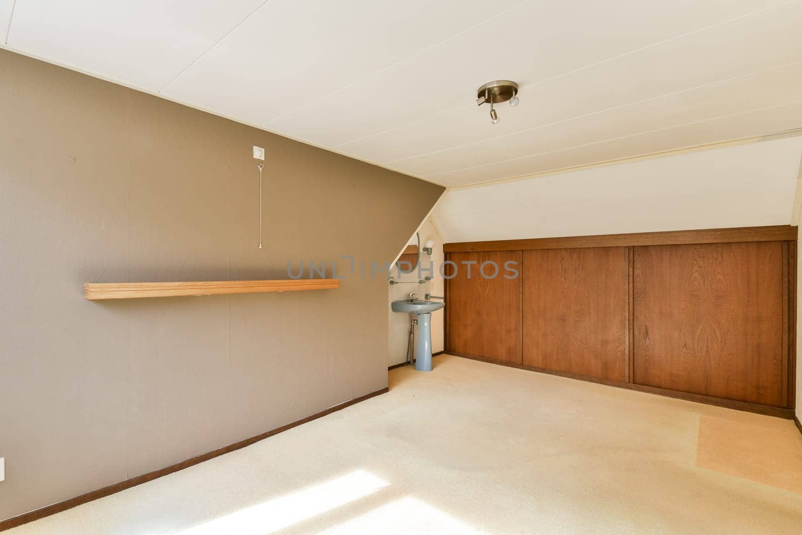 A minimalist interior featuring a wooden shelf and cabinets with a neutral color palette. The room exudes simplicity and elegance, ideal for various design ideas.