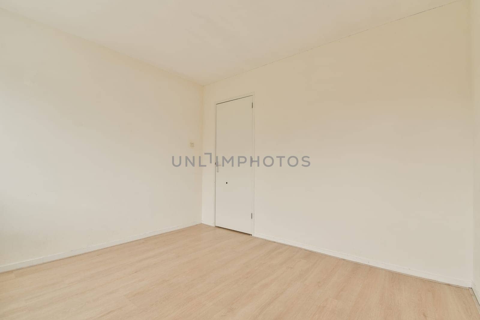 A minimalist interior featuring plain white walls and a light wooden floor, creating a spacious and airy environment perfect for design inspiration.