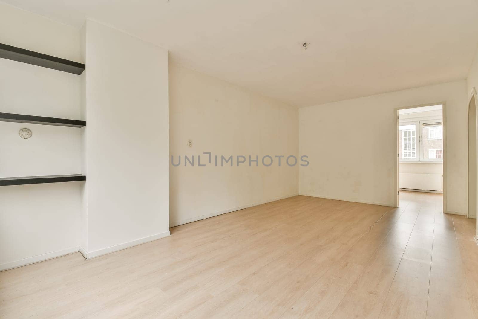 A spacious, empty room featuring light wooden flooring and white walls, creating a clean and minimalist aesthetic. Ideal for interior design inspiration.