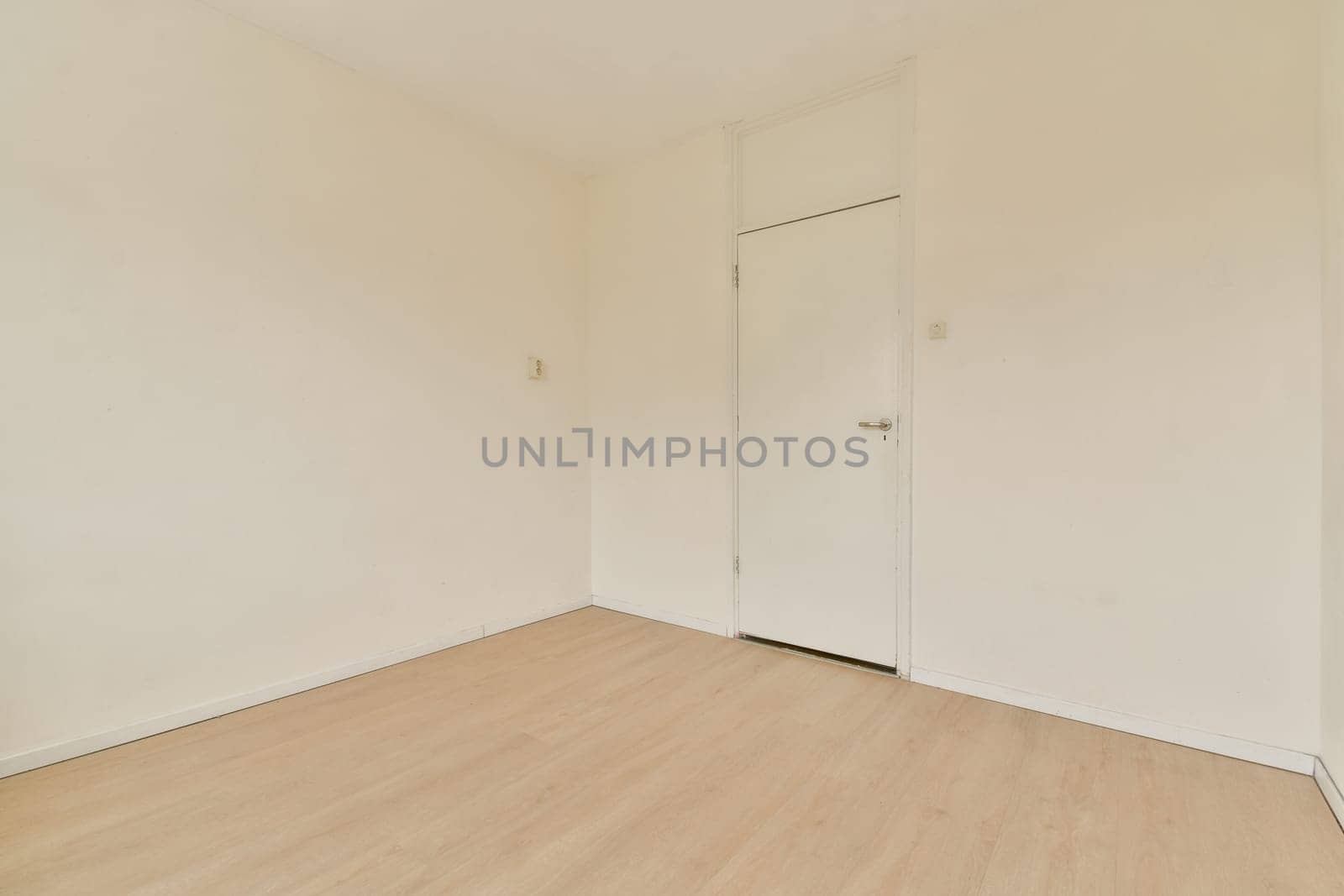 An empty room featuring bare walls and light wooden flooring, showcasing a minimalist aesthetic with ample natural light and simplicity throughout the space.