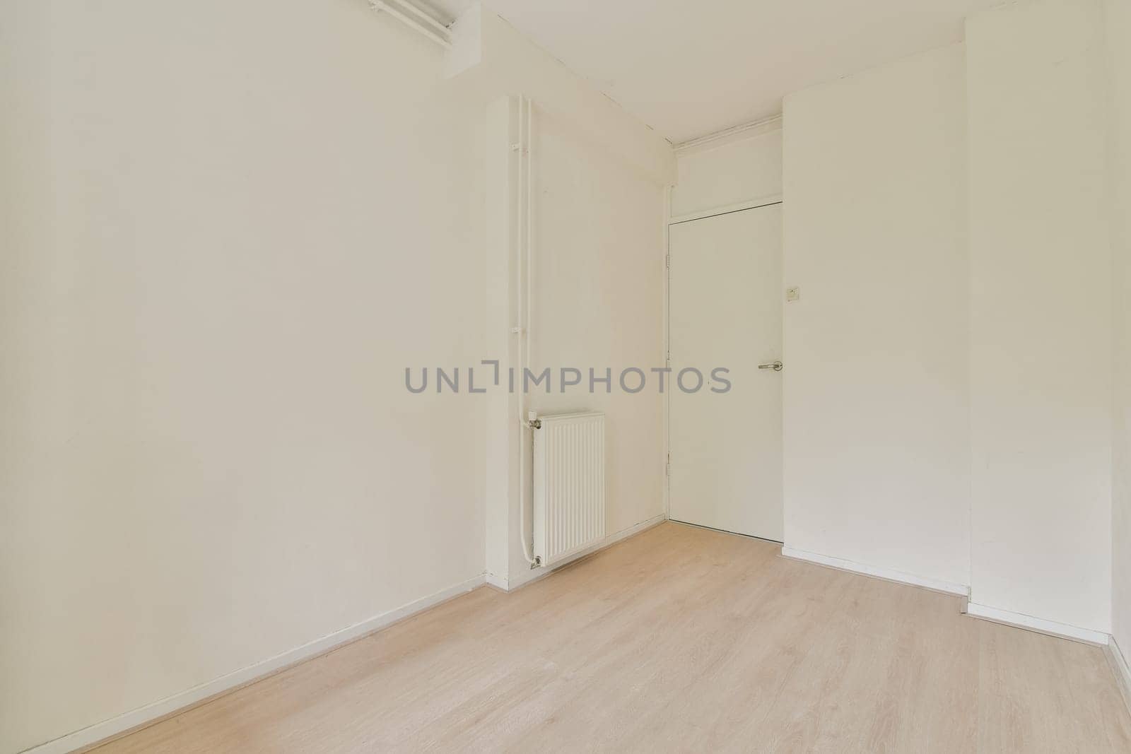 A spacious, minimalist room featuring plain white walls and wooden flooring, exuding simplicity and tranquility. Ideal for modern living concepts.