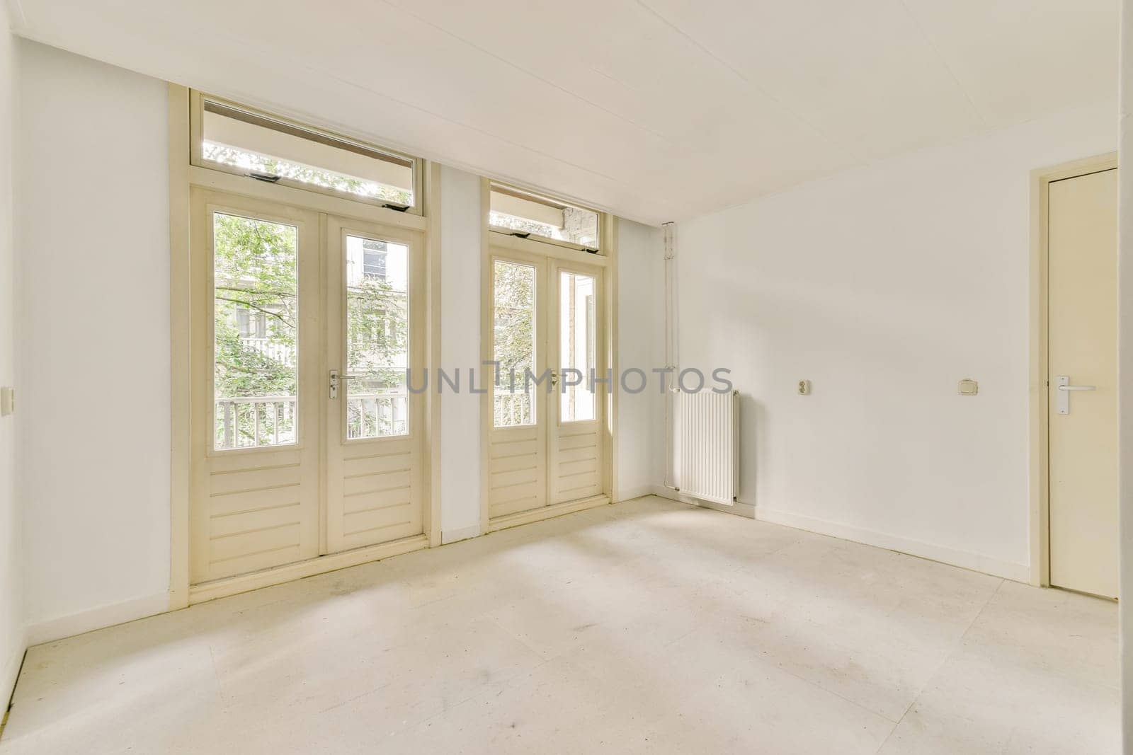 A spacious, bright, and minimalist interior featuring large windows that invite natural light. The clean lines and uncluttered design promote a serene ambiance.