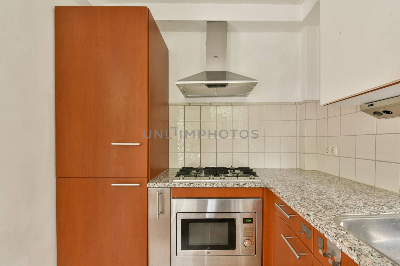 A contemporary kitchen featuring sleek cabinetry, a stainless steel oven, and a stylish cooktop, creating an inviting cooking space.