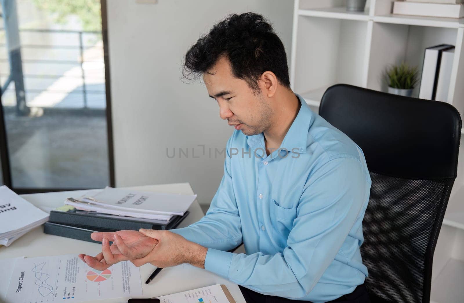 Office worker suffering from muscle aches and pains, highlighting the common issue of office syndrome in modern workspaces.