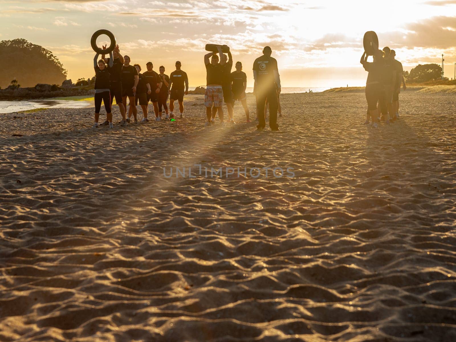 Mount Maunganui New Zealand - November 7 2012; Group of young adults exercising and building fitness in beach boot camp activity on Main Beach.