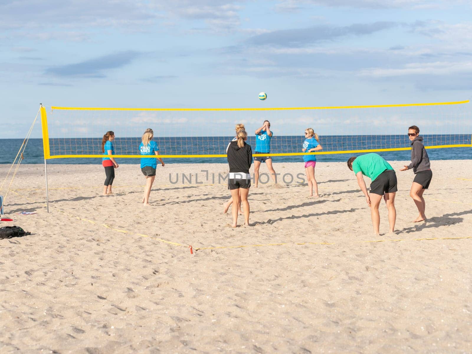 Mount Maunganui New Zealand - November 6 2012; Group of young adults playing beach volleyball on Main Beach.