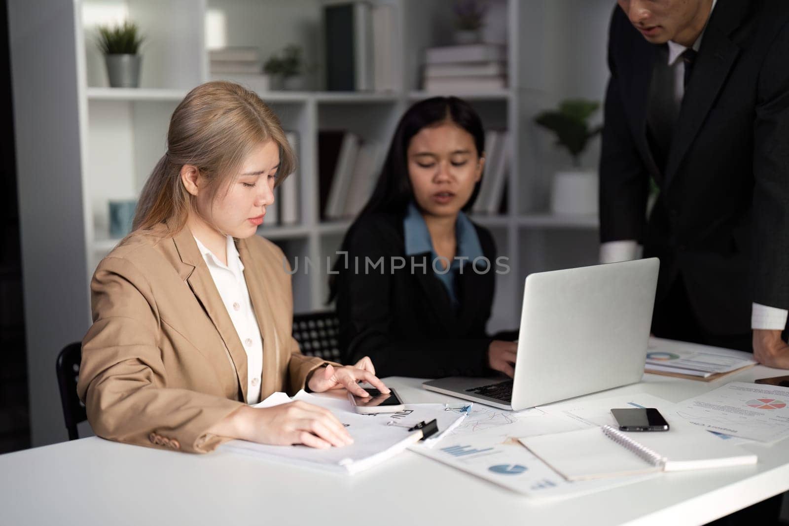 A group of business professionals engaged in a dynamic meeting, discussing strategies and exchanging innovative ideas in a modern office environment.