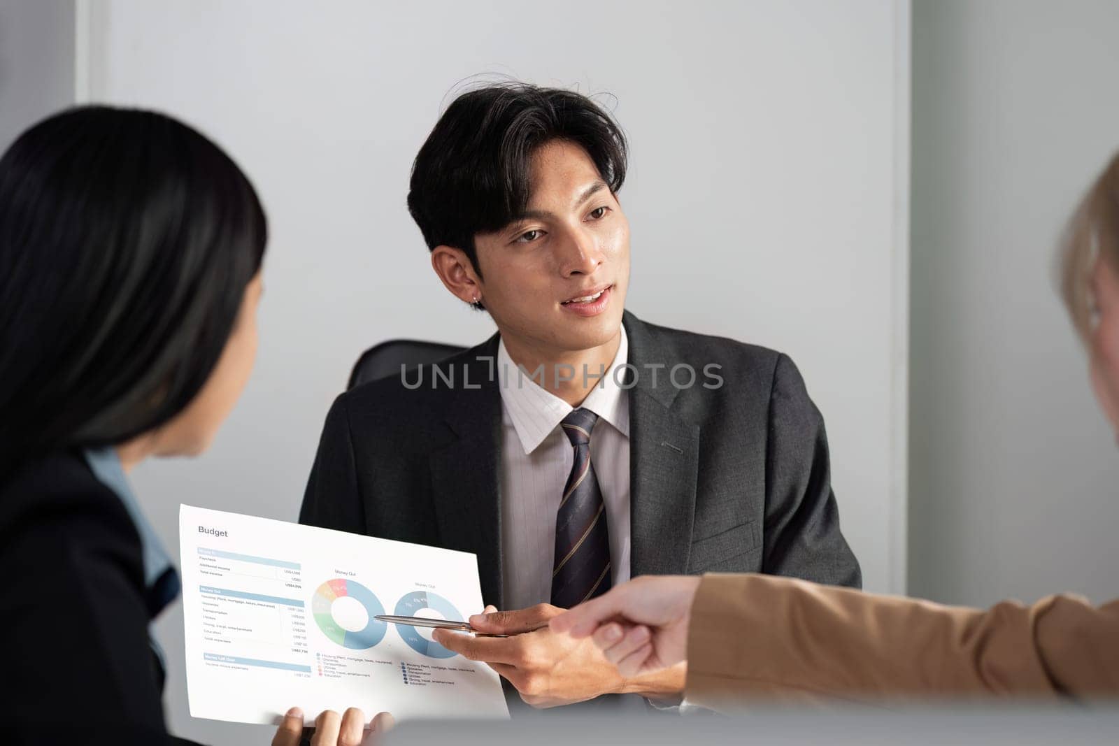 A group of business professionals engaged in a meeting, discussing strategies and exchanging ideas in a modern office environment.
