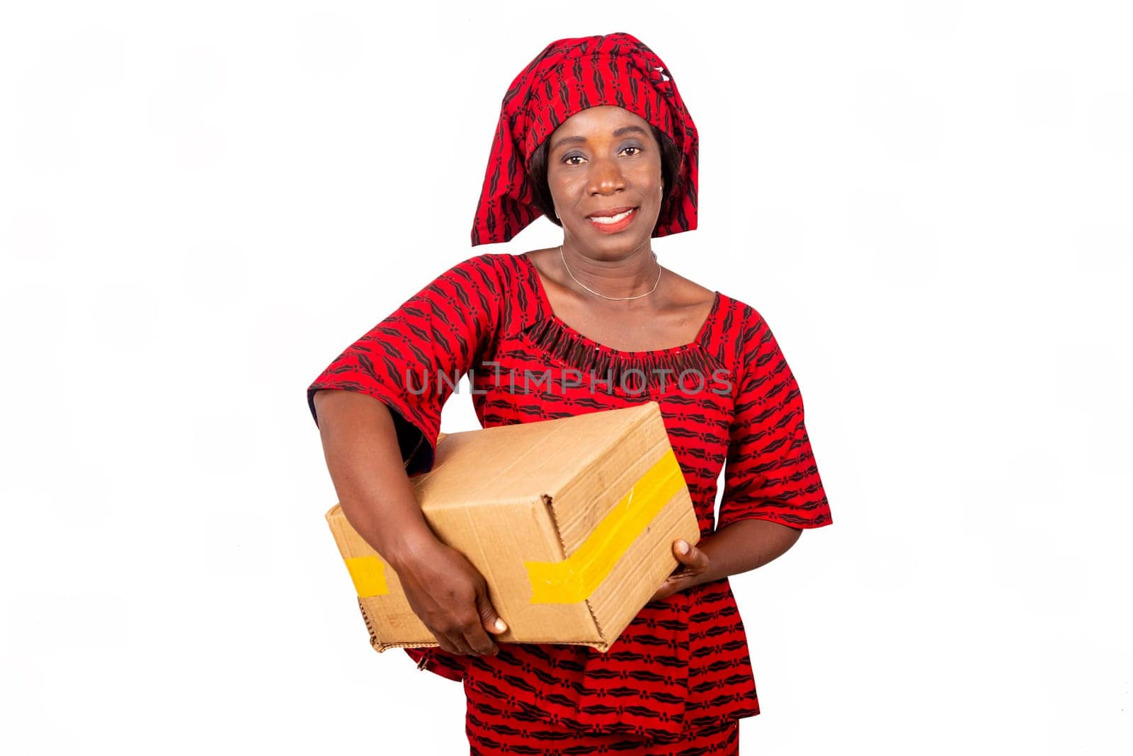 beautiful african adult woman dressed in red loincloth standing holding a cardboard box smiling. isolated on white background