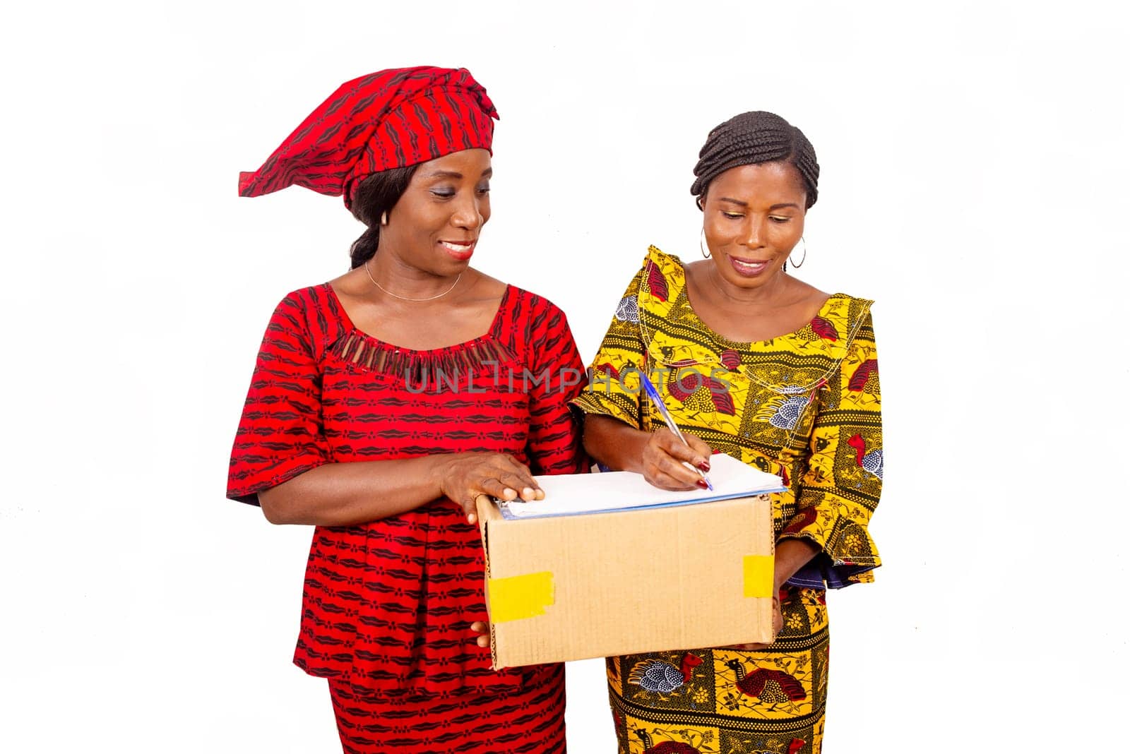 beautiful mature woman carrying a big package while and the businesswoman confirming receipt of delivery by signing it