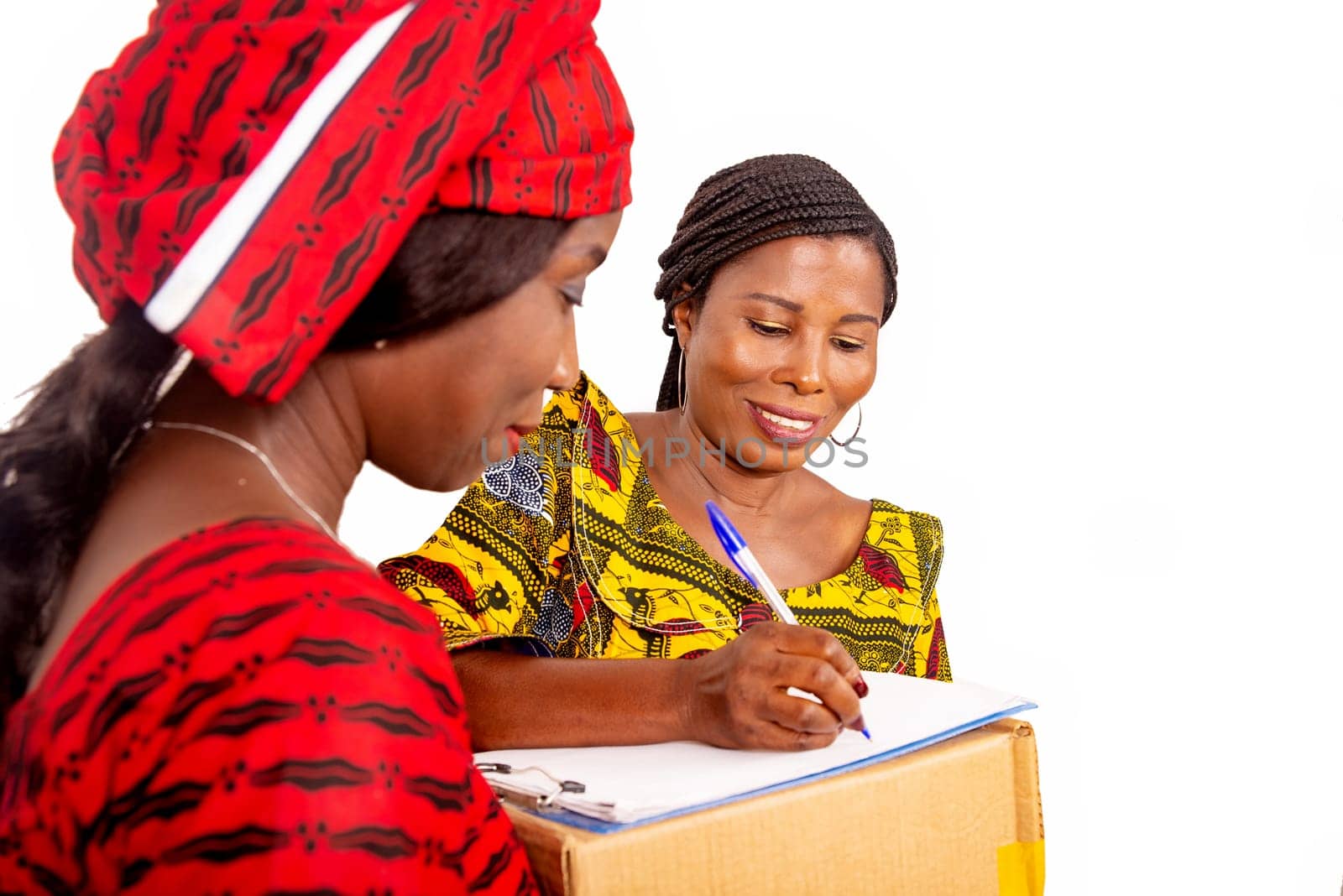 beautiful mature woman messenger carrying a large package while the business woman confirming receipt of delivery by signing