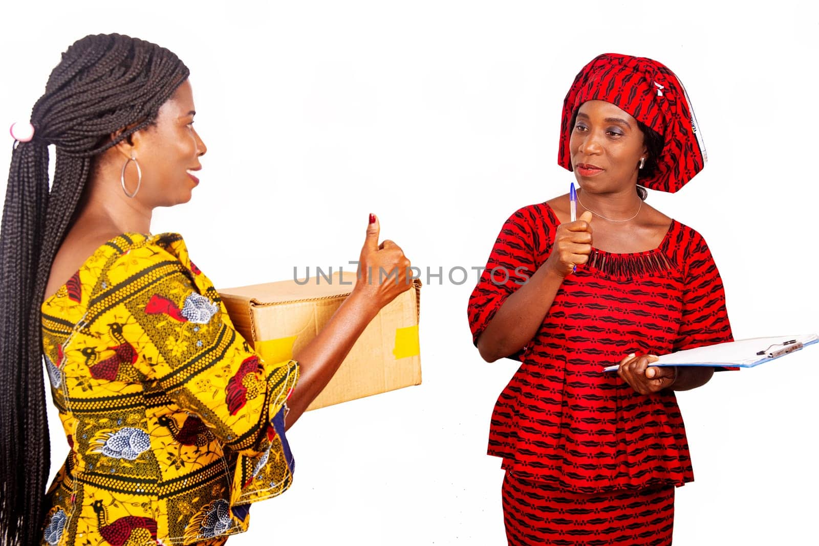beautiful adult businesswoman receives a cardboard package of an adult delivery woman in red loincloth with a pen and a signature in the hand