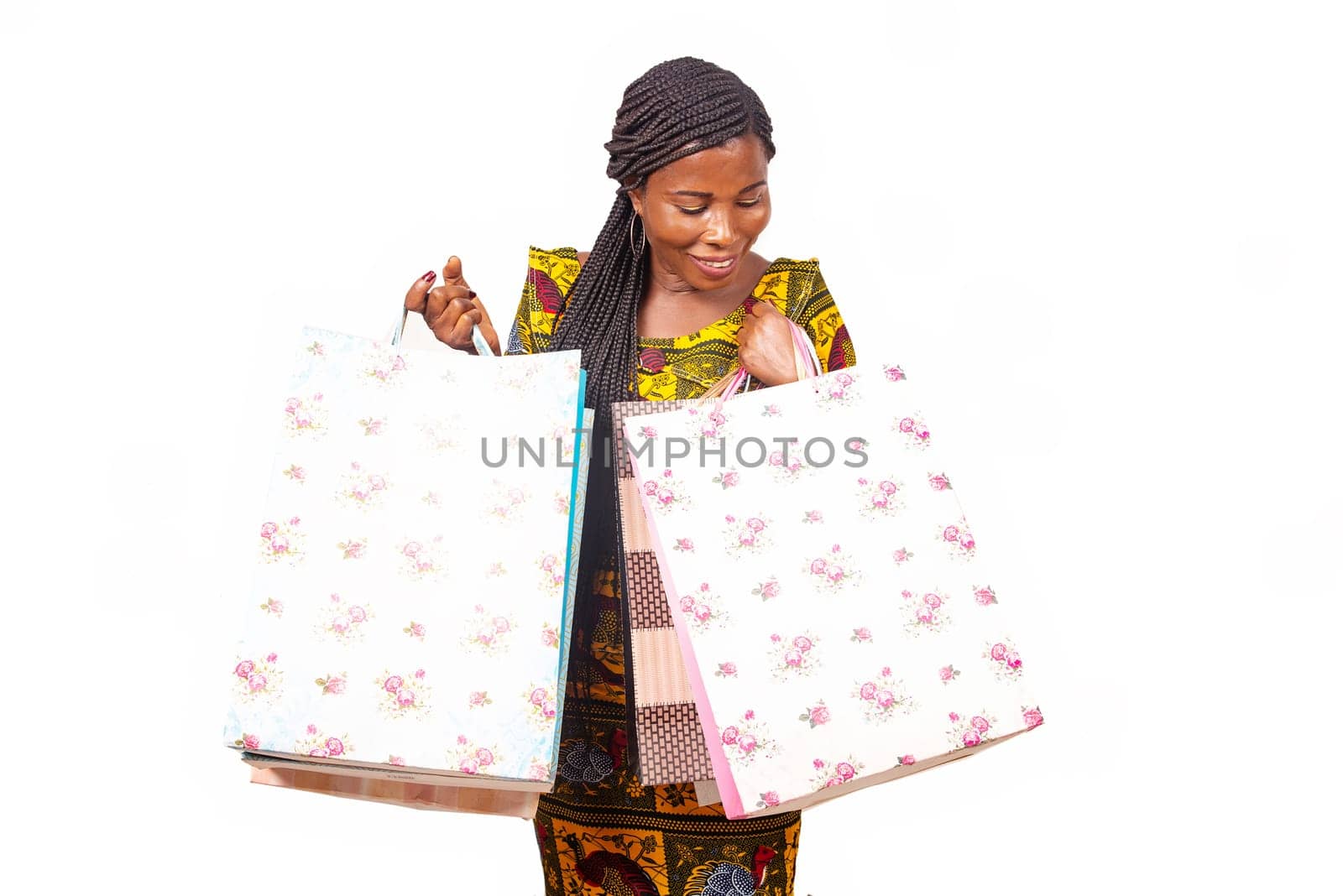 Portrait of happy african adult woman standing holding bags in hands and smiling while standing isolated on white background