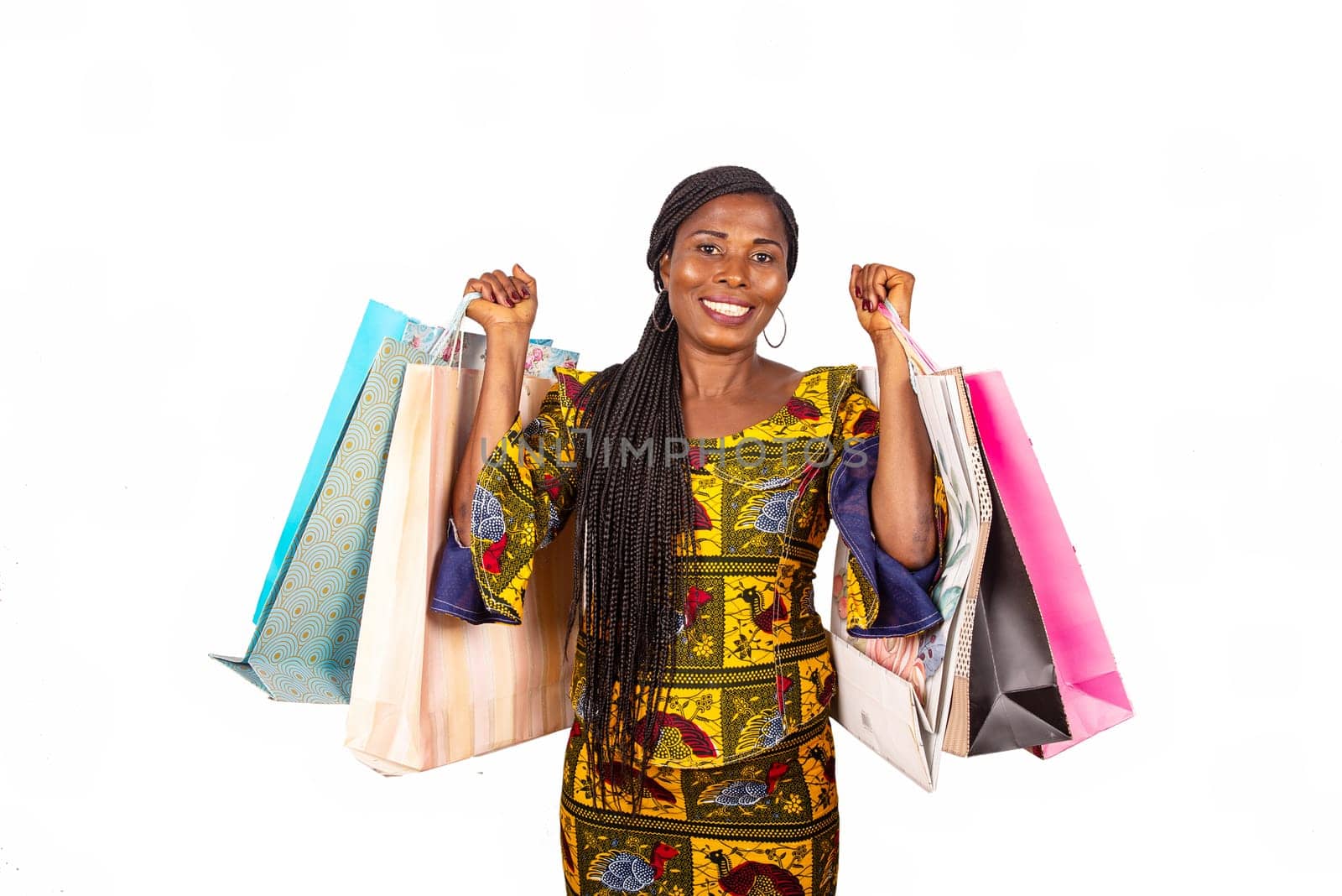 Portrait of happy african adult woman standing holding bags in hands and smiling while standing isolated on whiteground