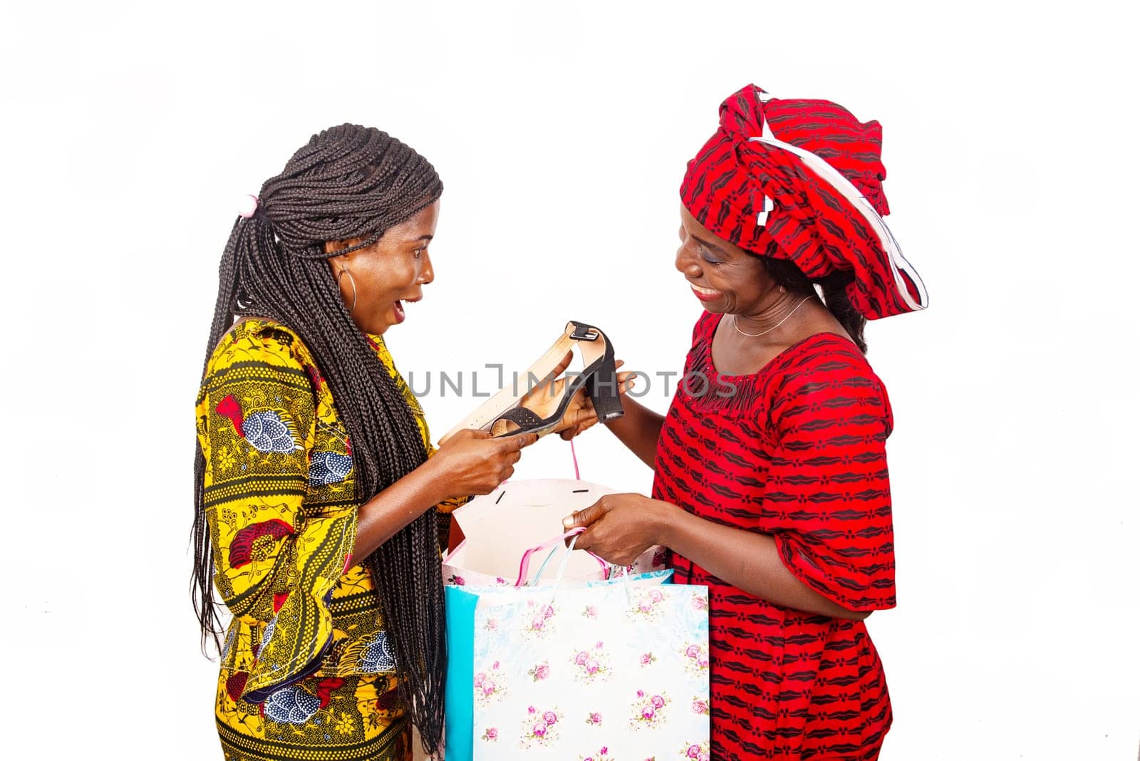 beautiful African adult customer is happy receiving a pair of shoes from a delivery service inside a woman wearing a red loincloth using bags