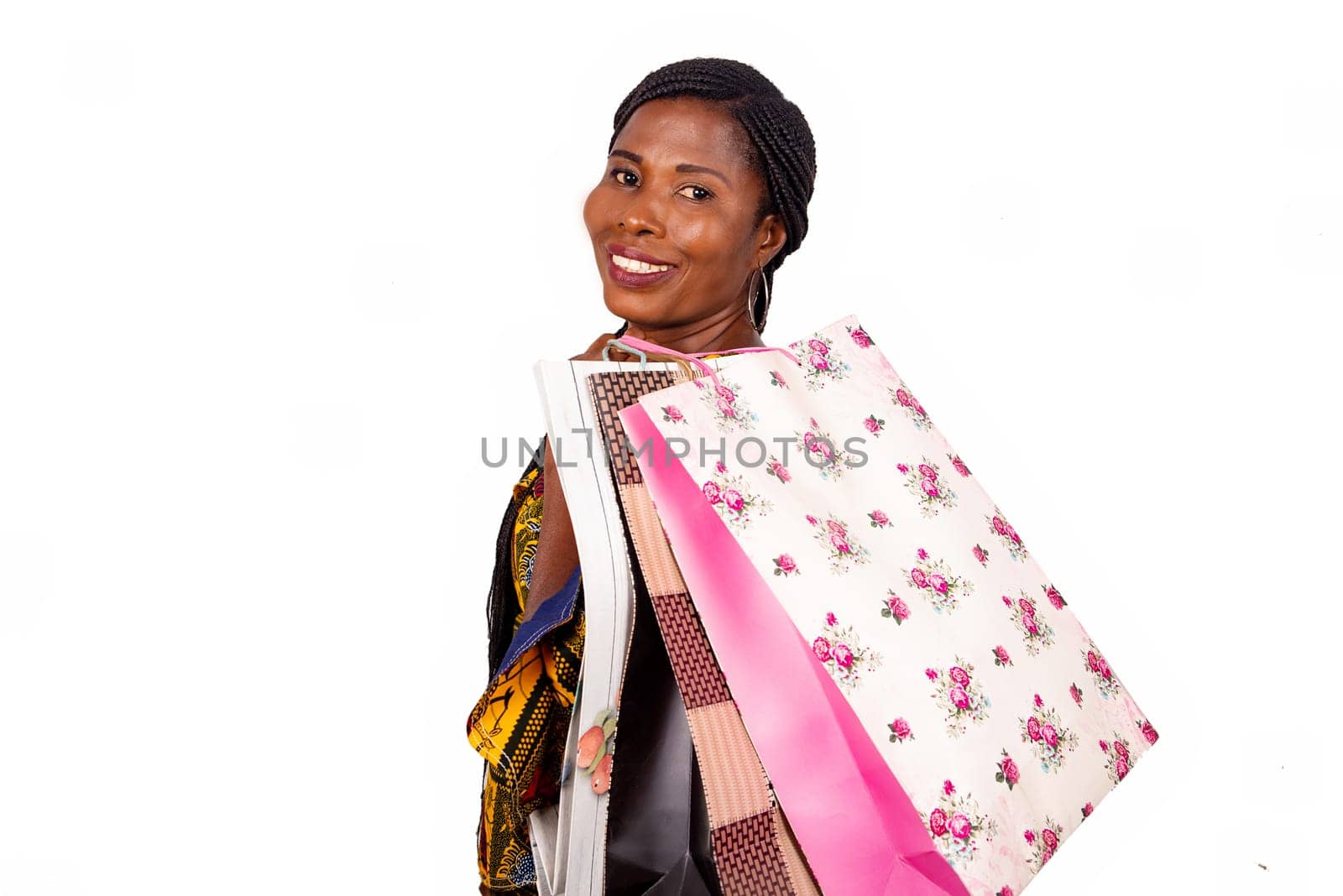 Portrait of happy beautiful african adult woman holding paper bags in hand and smiling while standing isolated on white background