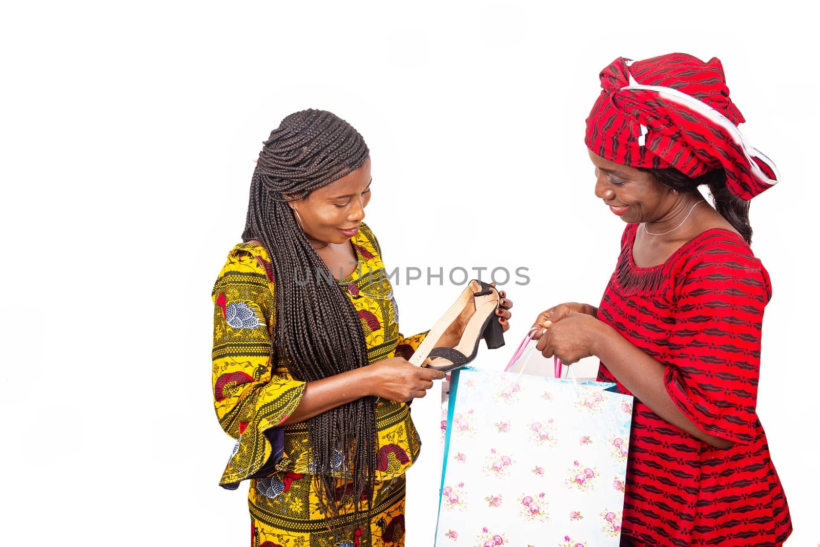beautiful african adult customer receiving a pair of shoes with home delivery service of a woman wearing a red loincloth with bags